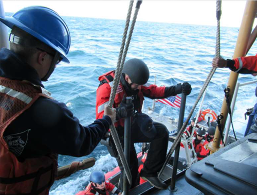A DEPENDABLE law enforcement team member climbs on board the cutter following avessel boarding. A DEPENDABLE law enforcement team member climbs on board the cutter following avessel boarding.